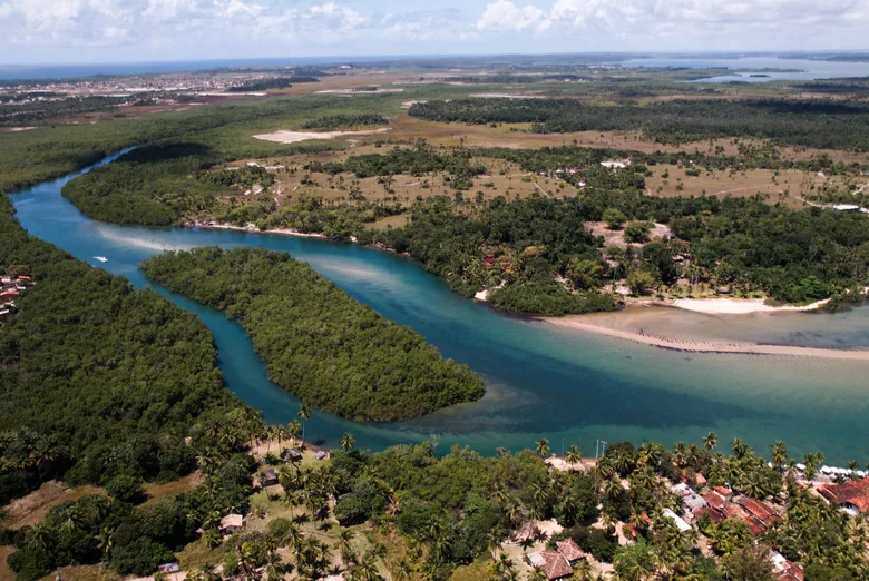 Aerial view of a river mouth between the forest and the sea, on the Maraú Peninsula